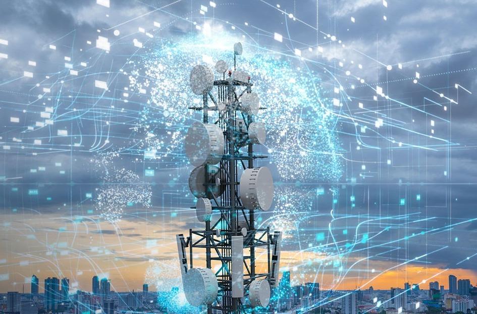 Una torre de telecomunicaciones con numerosas antenas, rodeada de gráficos de datos digitales, con un paisaje urbano y un cielo nublado al atardecer como telón de fondo.